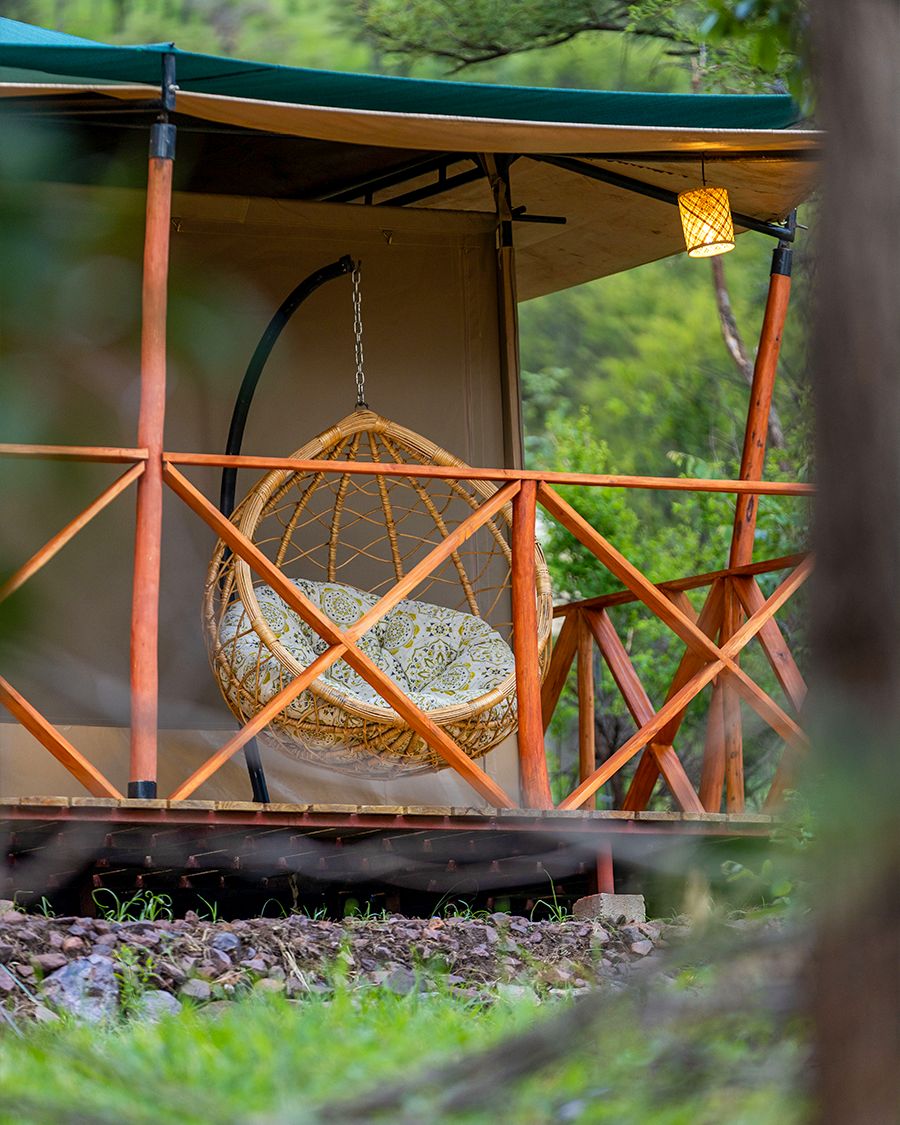 A hanging chair on a tent veranda