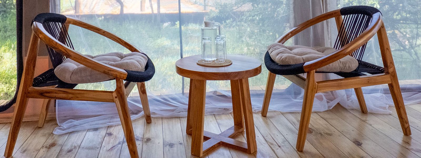 Two chairs and a small table on a tent veranda